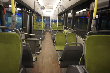 Plakat Innenausstattung mit grünen Sitzplätzen in ausgeleuchtetem Bus bei Nacht im Winter