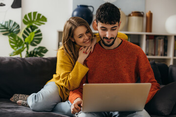Young caucasian couple looking at the laptop screen