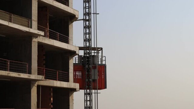 worker riding a construction elevator in construction Project