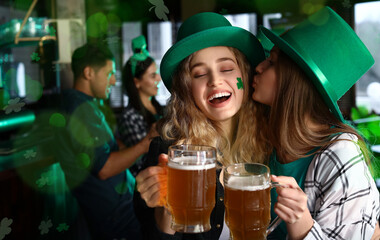 Young women with beer celebrating St. Patrick's Day in pub