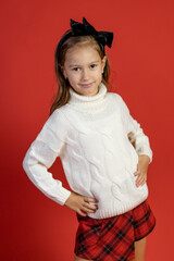 Portrait of cute little girl on red background