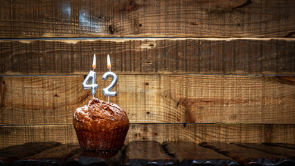 Background happy birthday pie or muffin with candles burning digit number  42. Festive card Happy...
