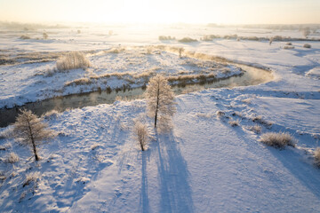 Winter sunrise over a misty river. winter morning by a steaming river. Sunny morning over a steaming river.