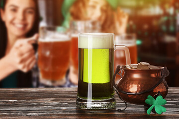 Glass of beer and pot with coins on table in bar. St. Patrick's Day celebration