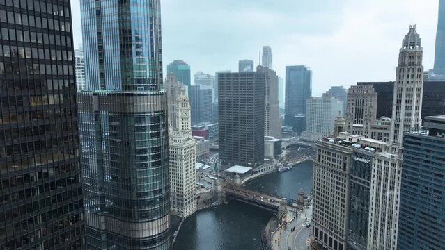 Aerial drone view flying in downtown Chicago loop over Chicago River on cold snowy winter day