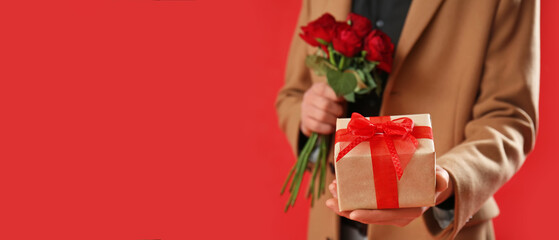 Woman holding gift and roses on red background with space for text. Valentine's Day celebration