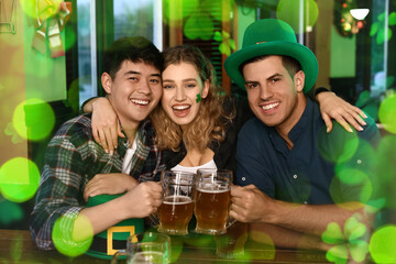 Happy young friends celebrating St. Patrick's Day in pub