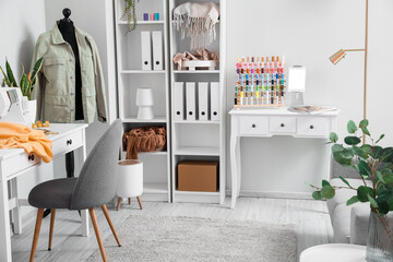Interior of atelier with tailor's workplace, mannequin and shelving unit