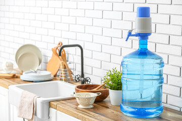 Bottle of clean water on kitchen counter near white brick wall