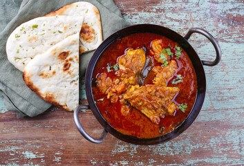 Traditional spicy Indian chicken Madras curry Rogan Josh with drumsticks, wings and garlic chapati...