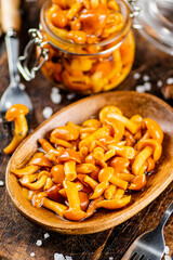 Marinated mushrooms on a wooden plate. 