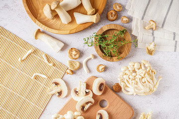 Composition with different fresh mushrooms on light background