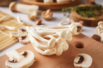 Fototapeta premium Wooden board with fresh mushrooms on table, closeup