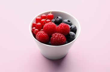 Bowl of fresh ripe berries on pink background