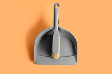 Plastic dustpan with brush on color background