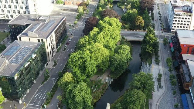 Avon river and green park through Christchurch city downtown – aerial 4k.
