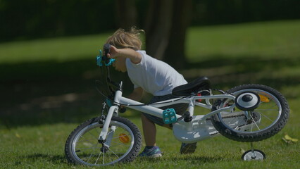 One small boy pushing bicycle falling off to ground bike falls to ground