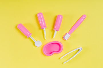 Children's dentist set. Yellow background. Flat lay. Medical, stomatology, kids toys concept. Profession choice.