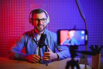 A video blogger records content in his studio. The backstage photo was taken from behind one of the...