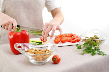 Healthy eating dieting concept. High angle view of female hands cutting cucumber in kitchen right...