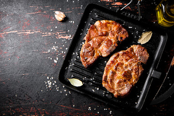 Grilled pork steak in a frying pan. 