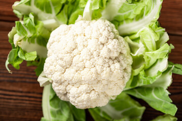 Whole cauliflower close-up on a wooden background. Vegetarian concept, healthy eating.
