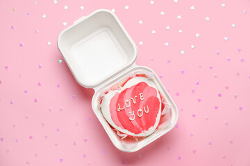 Plastic lunch box with heart-shaped bento cake on pink background. Valentine's Day celebration
