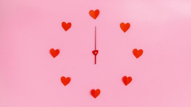 4k Red paper heart flies up to the clockwise and turns it back. Circle of hearts. Love time. A symbol of slowing down and turning back time for lovers. Stop motion animation. Copy space. Flat lay.