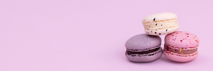 Banner sweet colorful macarons isolated on pink background.