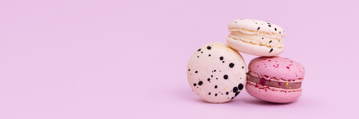 Banner sweet colorful macarons isolated on pink background.