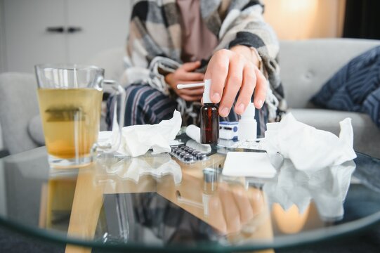 Close-up Man's Hands Holds White Plastic Bottle With Pills And Ready To Take Supplement Pill With Glass Of Water. Ill Man Taking Medication. Sick Person Need Medicine Against A Headache And Cold