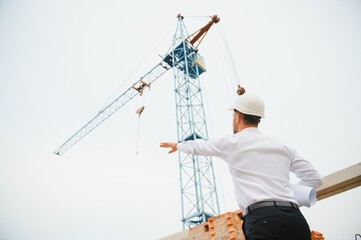 Construction concept of Engineer working at Construction Site with blue print.