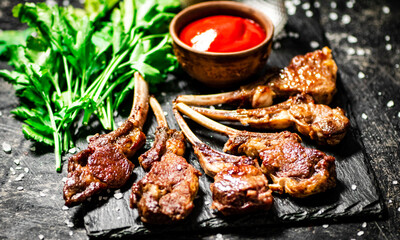 Rack of lamb with tomato sauce and parsley on the table.