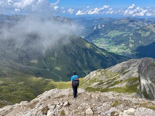 Man looking down on Bregenzerwald from Hochkuenzelspitze. Vorarlberg, Austria.