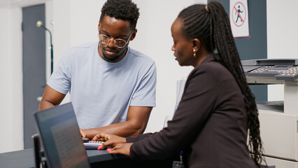 Man paying consultation and medicine with nfc mobile payment, using smartphone at pos terminal on reception counter. Adult making electronic transaction in lobby at health center. Handheld shot.