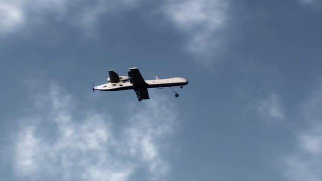 3D animation of military drone flight. Combat drone on military mission. Cloudy sky on background. Remotely-piloted aircraft. Concept of using modern UAV technology for military battles or in war.