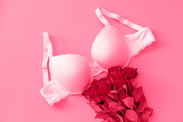 White new bra on a magenta background. Bra, lace lingerie on a viva magenta background. Beauty blog concept. Top view, flat lay. color of the 2023 year
