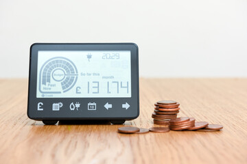 Smart meter and coins to represent cost of fuel and electricity for household bills