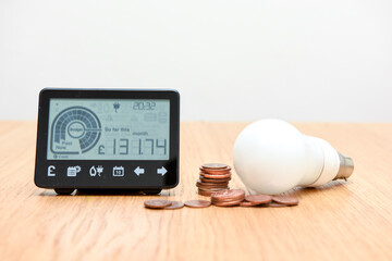 Smart meter and coins to represent cost of fuel and electricity for household bills