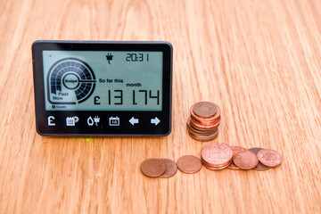 Smart meter and coins to represent cost of fuel and electricity for household bills