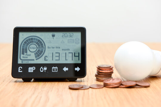 Smart meter and coins to represent cost of fuel and electricity for household bills