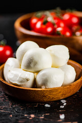 A wooden plate on a table with mozzarella. 