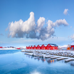 Breathtaking scenery wit traditional red wooden houses on the shore of Offersoystraumen fjord.
