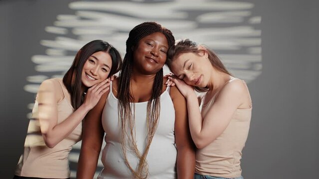 Healthy glowing ladies promoting self confidence in studio, having radiant natural skin posing on camera. Young diverse models emrabcing imperfections in new skincare campaign.