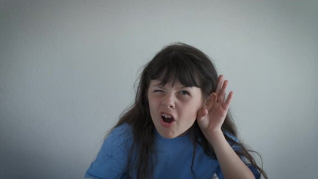 Child eavesdropping in the room. A cute little girl stay in the room and keep her hand by the ear to eavesdropping.
