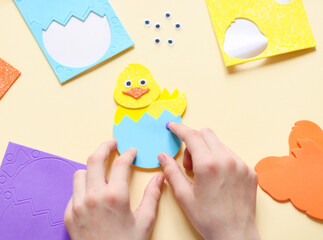 Hands of a caucasian teenage girl sticking a sticker of a blue shell with a zigzag