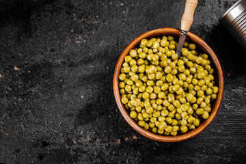 Canned green peas in a wooden bowl. 