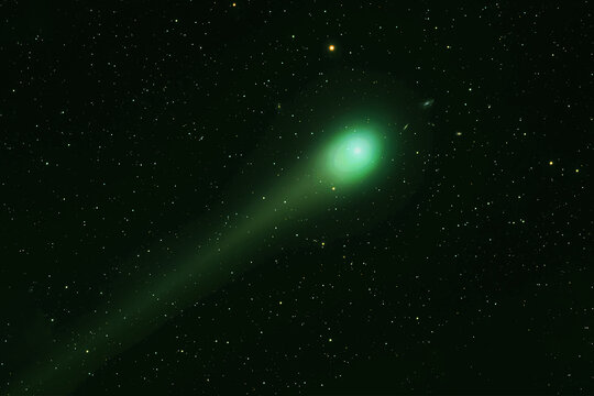 Green comet in dark space. Elements of this image furnished by NASA