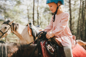 Young girl rides a horse through picturesque places.