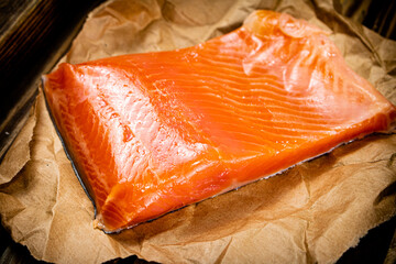 A large piece of salted salmon on a wooden tray. 